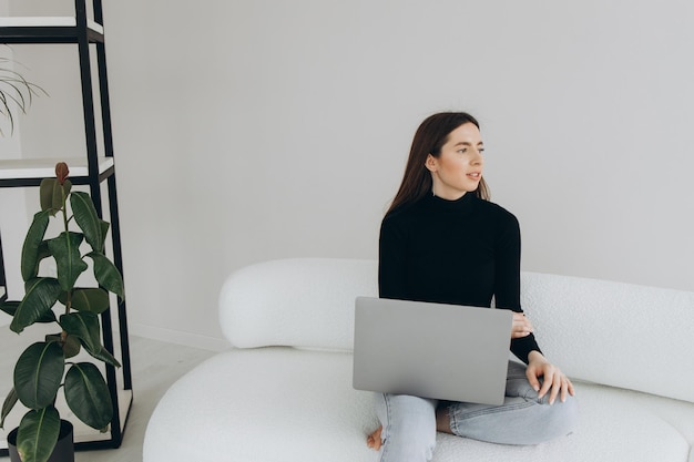 Hermosa joven usando la computadora portátil en casa