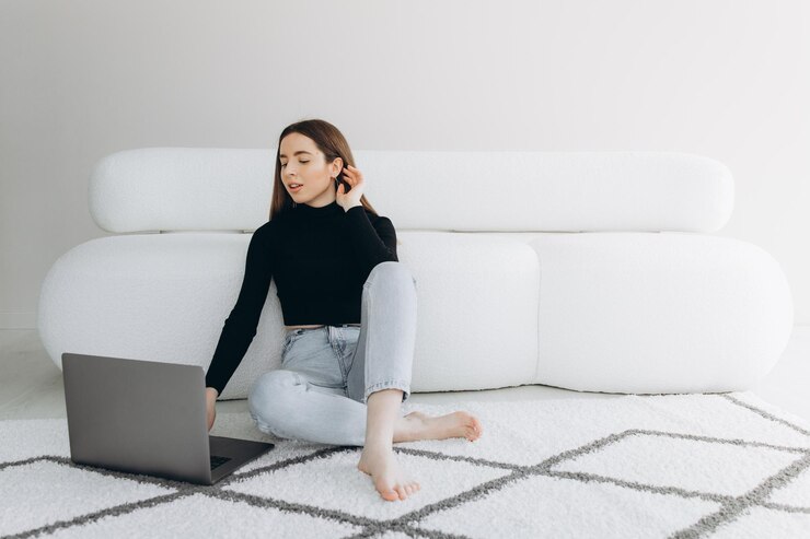 Hermosa joven usando la computadora portátil en casa