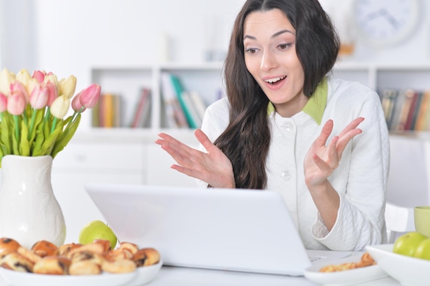 Hermosa joven usando laptop en la mesa