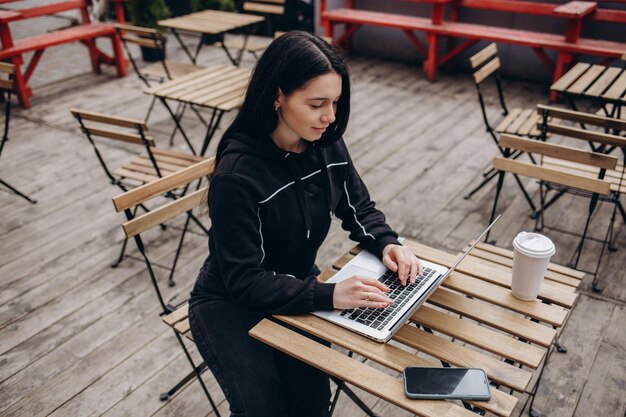 Hermosa joven usando tecnología al aire libre