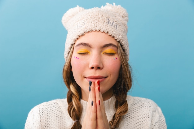 Hermosa joven vestida con ropa de invierno que se encuentran aisladas, mendigando