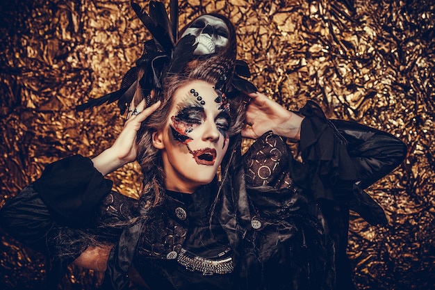 Hermosa joven vestida con traje oscuro. Maquillaje brillante y humo- tema de halloween.