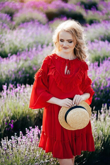 Hermosa joven con un vestido rojo en un campo de lavanda