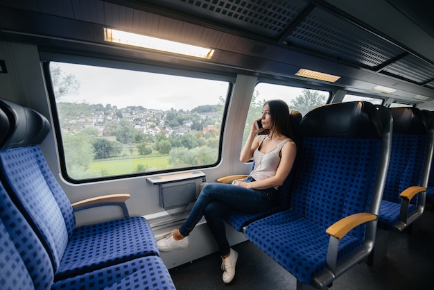 Hermosa joven viaja en un tren. Viaje. Transporte.