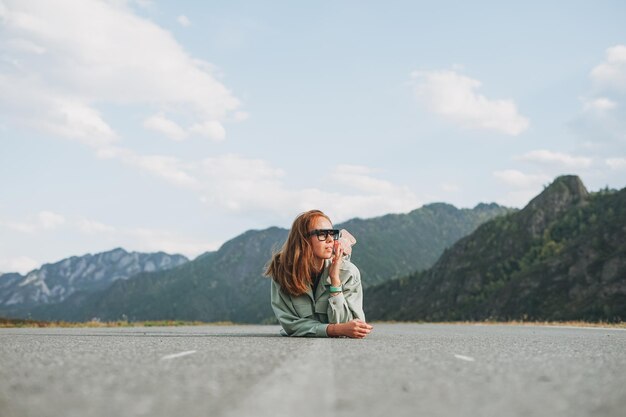 Hermosa joven viajera sonriente con ropa informal en un viaje por carretera a las montañas de Altai