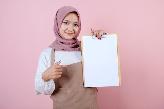 Hermosa joven vistiendo delantal con libro de menú sonrisa y feliz