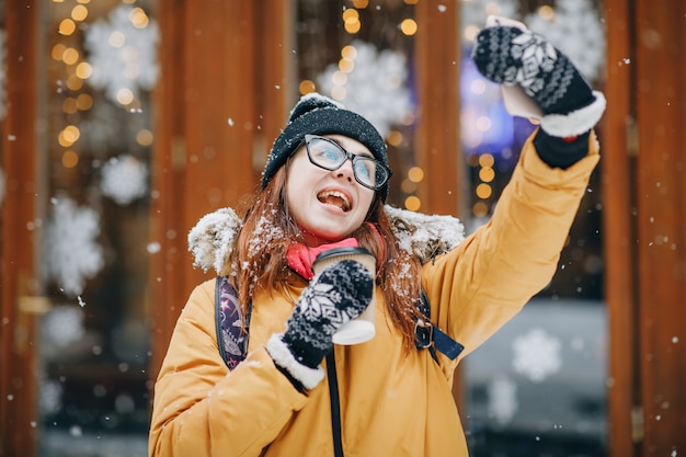 Hermosa jovencita en la ciudad nevada hace una selfie. Retrato de joven hermosa elegante en una ciudad de invierno