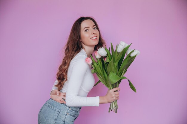 Hermosa jovencita emocionada de recibir un ramo de tulipanes para el Día de la Mujer