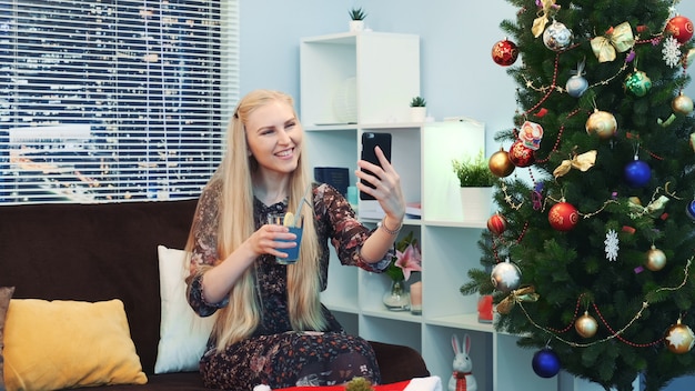 Foto hermosa jovencita está haciendo videollamada por teléfono inteligente