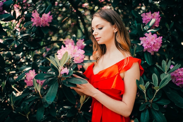 Hermosa jovencita posando entre el árbol en flor