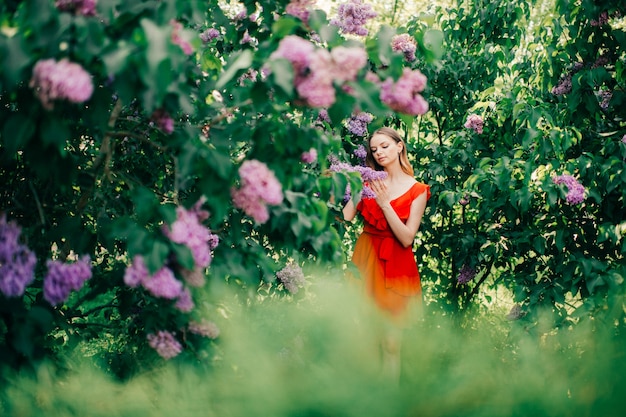 Hermosa jovencita posando entre el árbol en flor