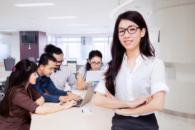 Hermosa líder femenina con empleados en la oficina