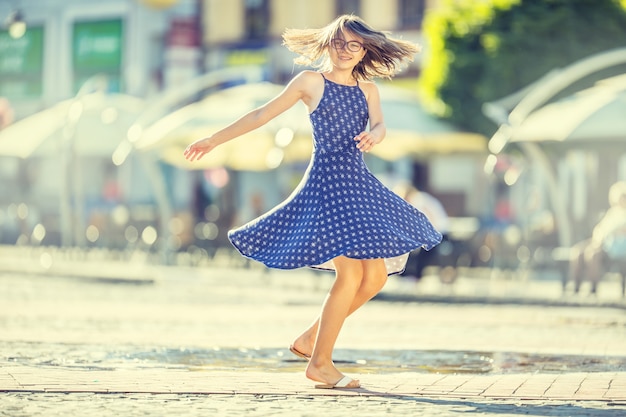 Hermosa linda joven bailando en la calle de la felicidad