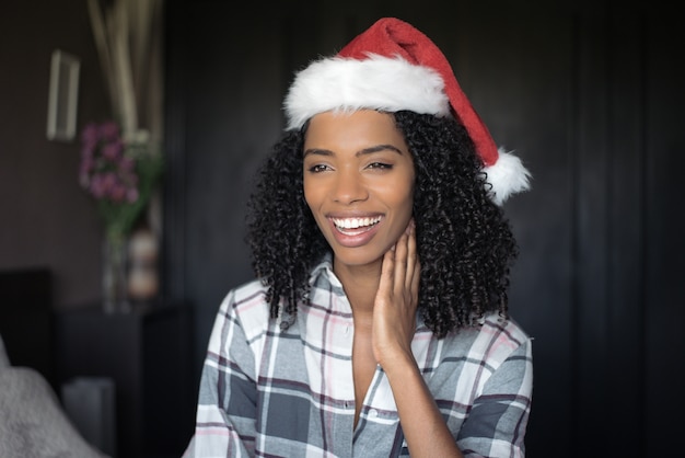 Hermosa linda joven negra en pijama en la cama con Christma