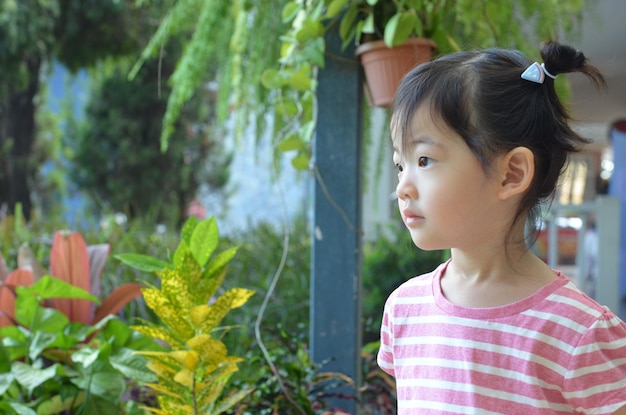 Hermosa y linda niña está mirando el espacio con fondo de grado