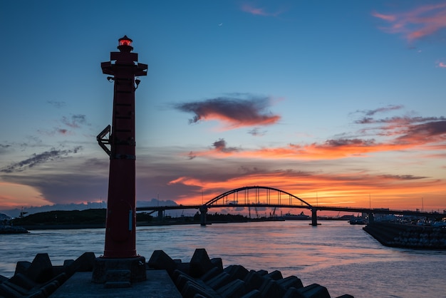 Hermosa luz del atardecer detrás del puente Southern Gate. Luz de señalización para navegación encendida en primer plano.