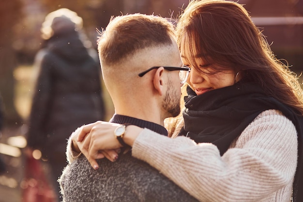 Hermosa luz del sol. Feliz pareja multirracial juntos al aire libre en la ciudad.