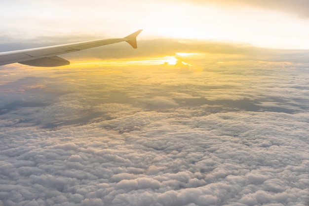 Hermosa luz del sol y nublado como se ve a través de la ventana de un avión