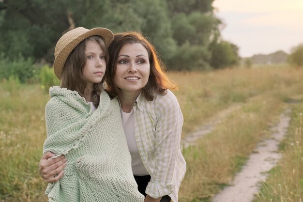 Hermosa madre abrazando a su pequeña hija, hablando, sonriendo