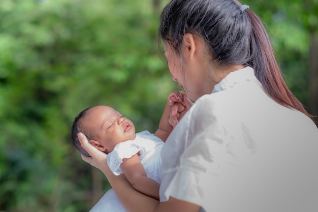 Hermosa madre asiática abraza a su bebé mientras duerme