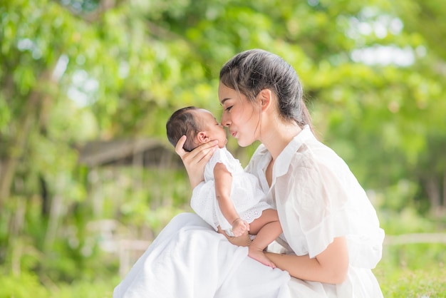 Hermosa madre asiática abraza a su bebé mientras duerme