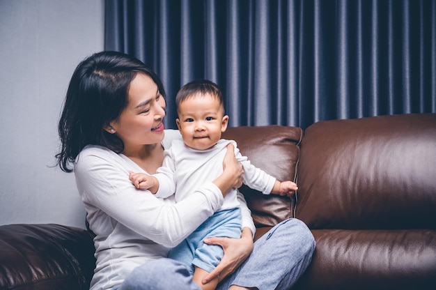 Hermosa madre asiática abrazando a su hijo.Concepto de familia feliz.