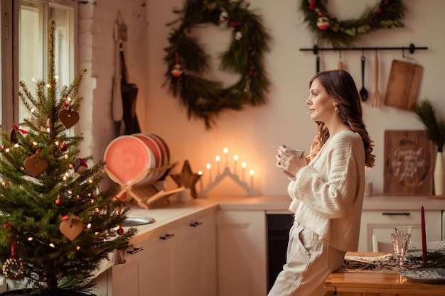 Hermosa madre e hija cerca del árbol de Navidad