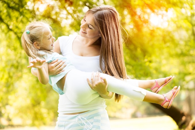 Hermosa madre e hija divirtiéndose en el parque.