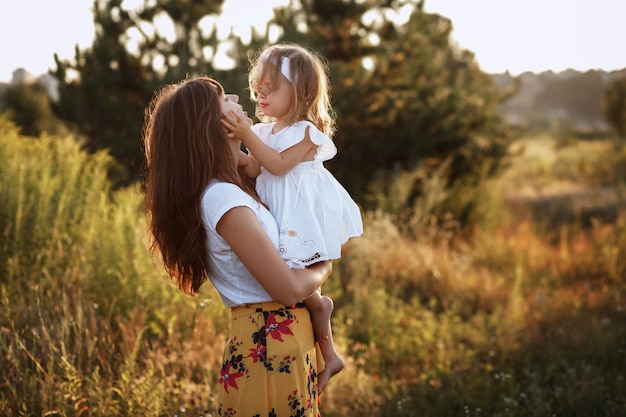 Hermosa madre e hija jugando en el campo