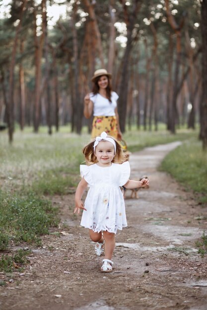 Hermosa madre e hija en un paseo por el bosque