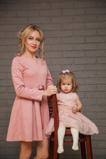 Hermosa madre e hija en vestidos rosas