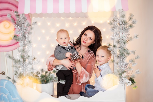 Hermosa madre e hijos con adornos navideños.