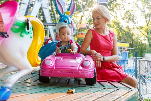 Hermosa madre con hijo en el coche de paseo