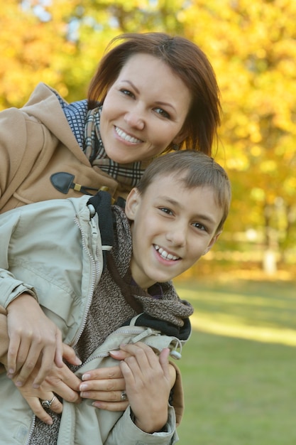 Hermosa madre con hijo en el parque otoño