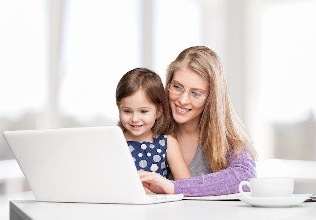 Hermosa madre y linda hija usando laptop