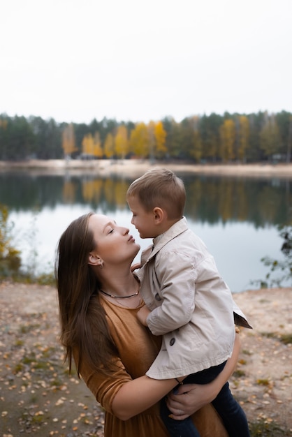 Hermosa madre sostiene a un hijo en sus brazos