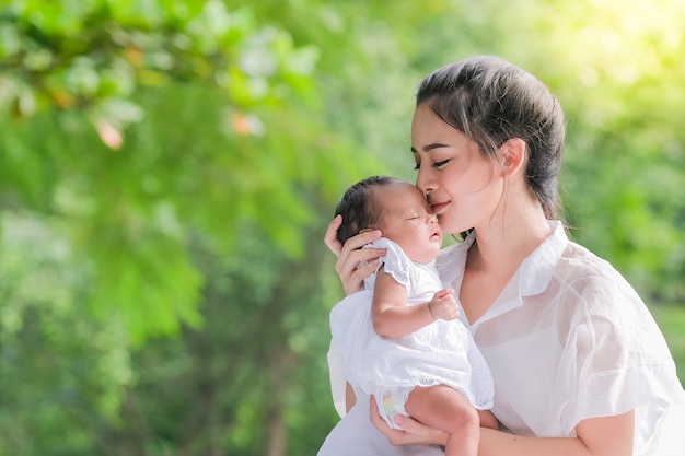 Hermosa madre y su bebé en un parque asiático