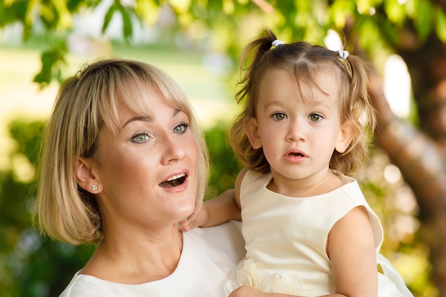 Hermosa madre con su hija al aire libre en el verano en el parque