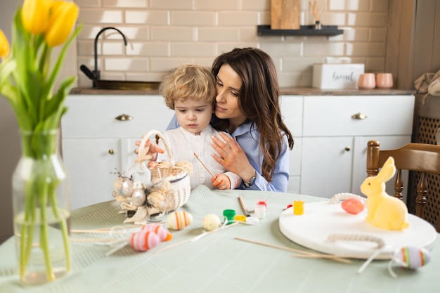 Hermosa madre y su hijo con cabello rizado blanco se preparan para Pascua