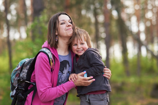 Hermosa madre y su lindo hijo caminando en el parque