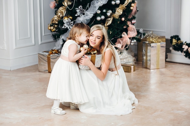 Hermosa madre con su niña en Navidad