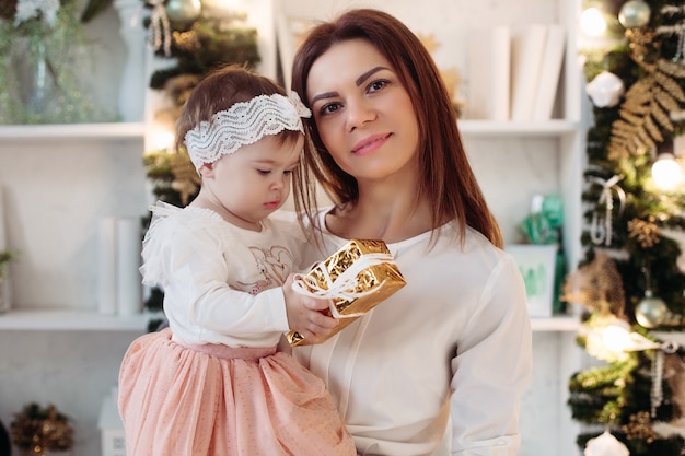 Hermosa madre con su niña en Navidad