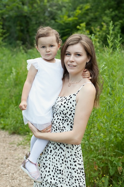 Hermosa madre y su pequeña hija al aire libre