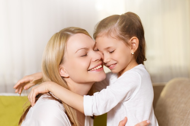 Hermosa madre y su pequeña hija están sonriendo