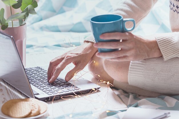 Hermosa mañana acogedora - niña sentada con una computadora portátil