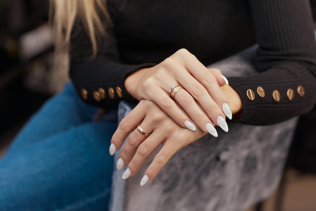 Hermosa manicura. Esmalte de uñas aplicado a mano, el esmalte es de color azul. primer plano de fondo azul.