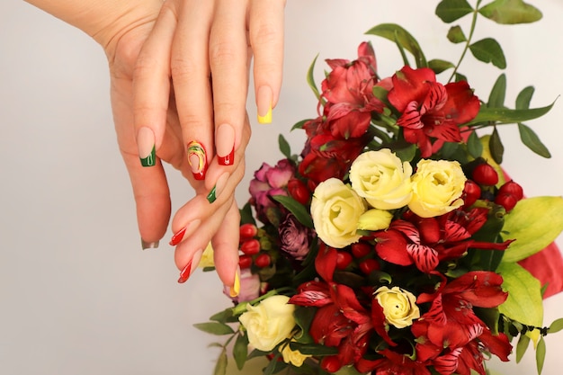 Hermosa manicura francesa en la mano de una mujer con flores.