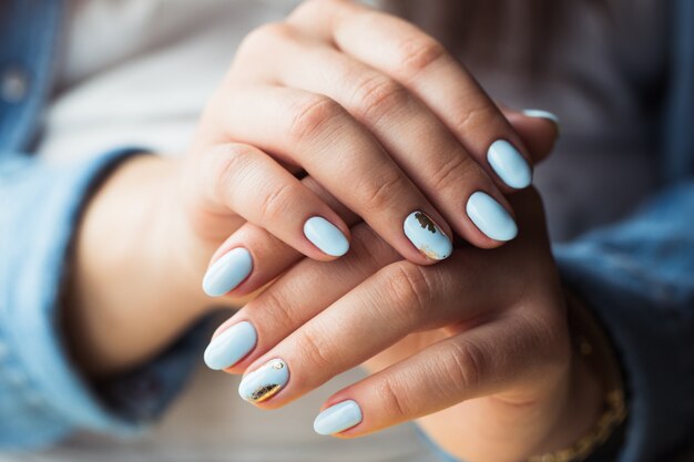 Hermosa manicura Recubrimiento de gel polaco en azul, relieve.