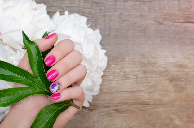 Hermosa mano femenina con diseño de uñas rosa