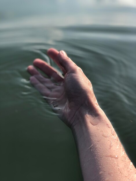 Foto la hermosa mano de una joven en el agua